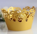 Vista macro di pirottini per cupcake in oro tagliati al laser con motivo a foglie - Oro