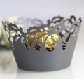 Macro shot of grey laser-cut cupcake wrapper with floral patterns and a gold chocolate - Silver Charcoal