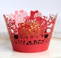 Detail of red laser-cut cupcake wrapper with floral patterns and a gold-wrapped chocolate - Pearlescent Red