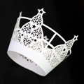 Detail of laser-cut white paper cupcake wrapper with hollow stars and vine patterns - White