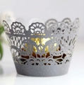 Macro detail of laser-cut silver lace cupcake wrapper with intricate floral hollow design - Silver Charcoal