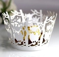 Detail of laser-cut owl and tree branch pattern on white cupcake paper wrapper - White