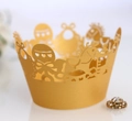 Detail of gold laser-cut cupcake wrappers with intricate carousel and heart patterns - Gold