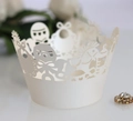 Detail of cream laser cut cupcake wrapper with baby shower bottle and rattle patterns - Ivory