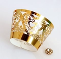 Detail of laser-cut gold hollow cupcake wrapper with floral heart patterns and rhinestone - Reflective Gold