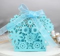Detail of light blue laser-cut wedding favor box with elegant floral patterns and ribbon - Tiffany Blue