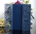 Detail of navy blue laser-cut wedding invitation with intricate lace floral patterns - Ink Blue