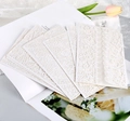 Elegant laser cut lace wedding invitation covers in off-white on a magazine backdrop - HK-8 (Floral Lace Style)