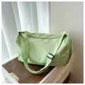 Detail of light green Oxford fabric travel bag with adjustable strap on wooden table - Light Green
