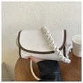 Close-up of white lychee leather bag with brown edges and woven handle detail - White With Pendant