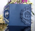 Dettaglio macro dell'invito tagliato al laser in carta perlata blu navy con motivo uccellini - Blu inchiostro