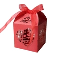 Macro detail of red laser-cut candy box featuring heart and bird motifs with ribbon - Red