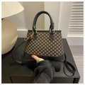 Dettaglio della borsa vintage con motivo dorato e manici in pelle nera di alta qualità - Nero