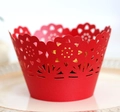 Nahaufnahme roter Laser-Muffin-Förmchen mit Hohlmuster aus Sonnenblumen und Rosen - Perlrot