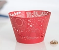 Macro view of red laser-cut cupcake wrappers with sun patterns for wedding decoration - Pearlescent Red