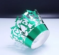 Macro detail of laser-cut green metallic cupcake wrapper with LOVE and heart patterns - Reflective Green