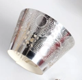 Close-up of laser-cut silver muffin liners with elegant sunburst lace pattern for wedding cakes - Reflective Silver