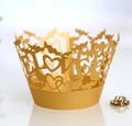 Macro detail of laser-cut gold pearlescent cupcake wrappers with LOVE heart pattern - Gold