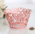 Macro shot of laser-cut heart pattern cupcake wrapper in pearlescent light pink - Pink