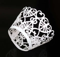 White laser-cut heart pattern cupcake wrapper with intricate lace design on black background - White
