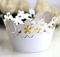 Close-up of laser-cut white cupcake wrappers with sunflower patterns and chocolate interior - White