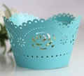 Close-up of sky blue laser-cut cupcake wrapper with intricate rose flower hollow patterns - Teal Blue