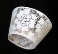 Detail of laser-cut white cupcake wrapper featuring a delicate black rose floral pattern - 5cm / White