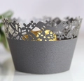 Macro view of dark grey laser-cut cupcake wrapper with floral and butterfly patterns - Silver Charcoal