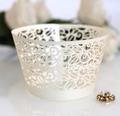 Detail of laser-cut lace cupcake wrappers with intricate floral vine patterns in cream white - Ivory