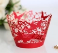 Close-up of red laser-cut cupcake wrapper with intricate butterfly and floral patterns - Pearlescent Red