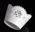 Vista macro di involucri per cupcake in carta perlata bianca con rose intagliate - Bianco