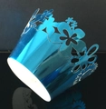 Macro detail of sky blue laser-cut cupcake wrapper with floral and butterfly patterns - Reflective Blue