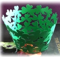 Nahaufnahme grüner Laser-Cupcake-Förmchen mit Kleeblatt-Hohlmuster für St. Patrick's Day - Dunkelgrün