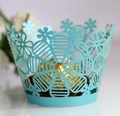 Detail of light blue laser-cut cupcake wrappers with floral patterns and gold chocolate - Tiffany Blue