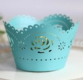 Macro view of laser-cut light blue cupcake wrapper with intricate rose patterns - Tiffany Blue