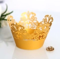 Detail showing laser-cut gold crown cupcake wrapper with intricate scrollwork patterns - Gold