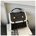 Dettaglio della borsa vintage stile college in pelle nera con bordo in lana agnellata - Nero
