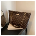 Dettaglio del motivo geometrico vintage e catena dorata sulla borsa shopper marrone - caffè