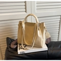 Dettaglio della borsa a secchiello beige con tracolla intrecciata e ganci in metallo - Bianco Sporco