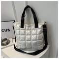 Detalle del bolso tote acolchado plateado con correas negras y textura de brillo metálico - Plateado