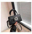 Detail of black leather crossbody bag featuring a rhinestone buckle and scrunchie handle - Black