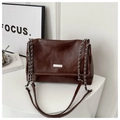 Close-up of dark brown glossy leather texture and silver MIKAXIQI metal logo on chain bag - Coffee
