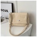 Detail of beige leather bag with silver chain strap and metal logo plaque on a white pedestal - Khaki