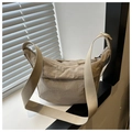 Dettaglio della borsa a tracolla in nylon beige con tracolla regolabile vicino alla finestra - Cachi
