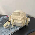 Bolso bandolera de pana beige con bolsillo delantero sobre fondo de mezclilla - Blanco Roto