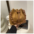 Detail view of brown suede bucket bag with woven leather handle and plush charm - Brown Without Pendant