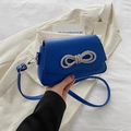 Fashionable Klein blue crossbody bag with rhinestone bow detail on blazer background - Blue