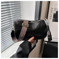 Detail of black leather cylinder bag featuring a boho wide embroidered shoulder strap - Black