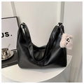 Detail of black pebbled PU leather tote bag with a pink plush charm on a white pedestal - Black With Pendant