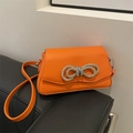 Sac bandoulière orange vif orné d'un fermoir nœud scintillant serti de diamants - Orange